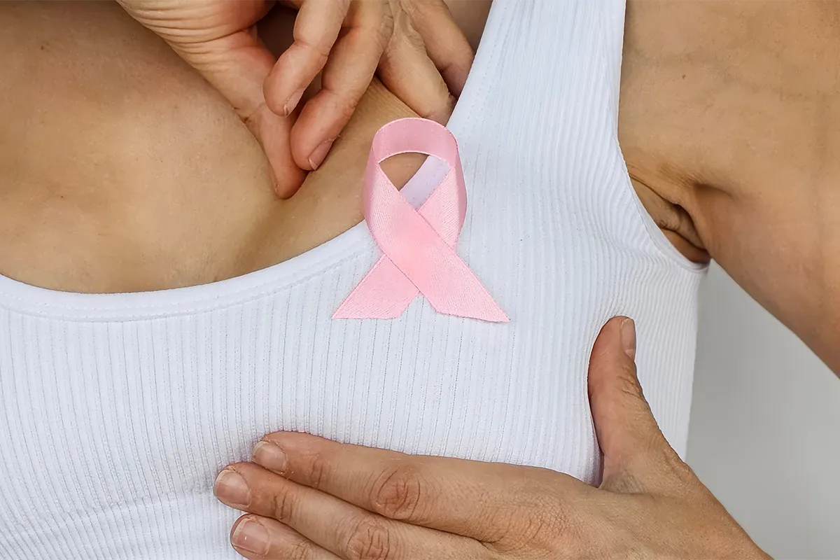 Auto-examen mammaire avec ruban rose de sensibilisation au cancer du sein.