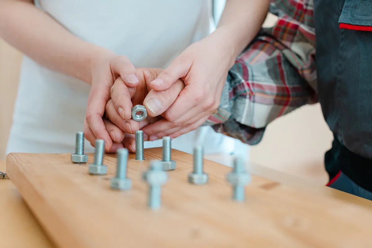 enfant aidé d'une ergothérapeute pour faire un jeu de motricité